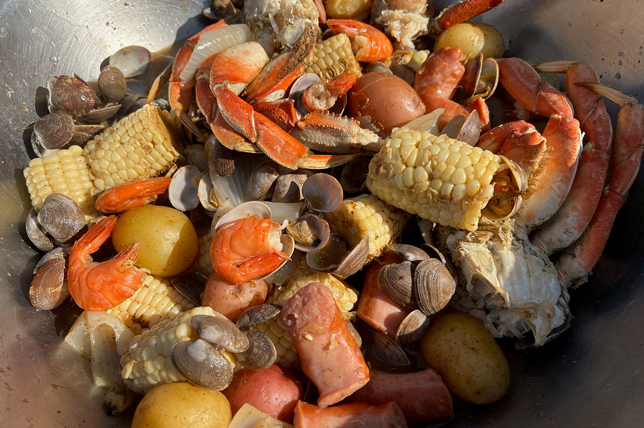 Pacific Northwest Seafood Boil for 6 to 8 people containing clams, crab, prawns, and sausage