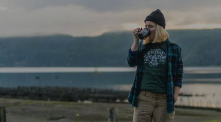 image of a person drinking out of a mug in front of the hood canal 